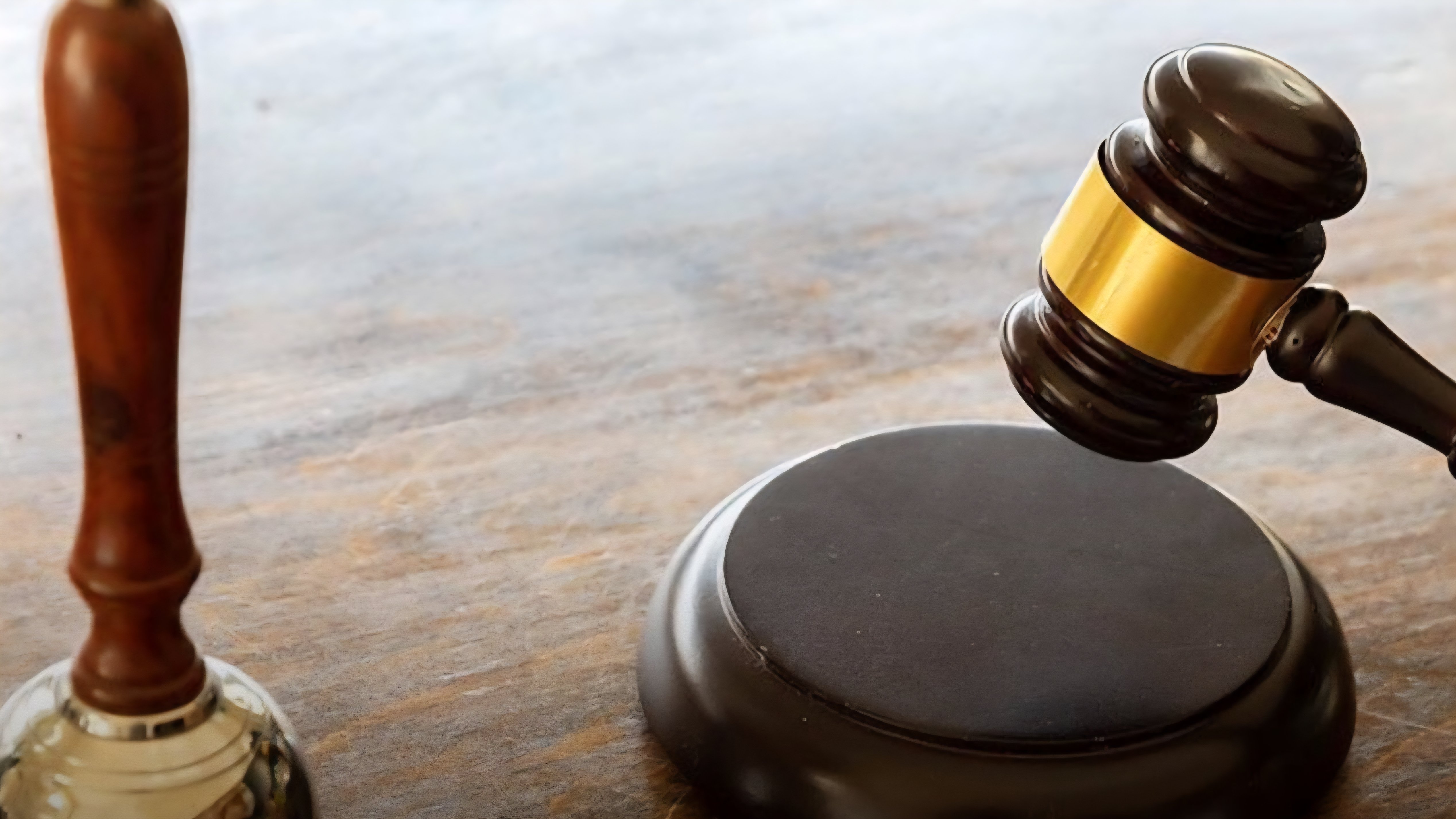 A wooden gavel resting beside a brass bell on an office desk, illustrating judicial rulings on Kenyan employment law.