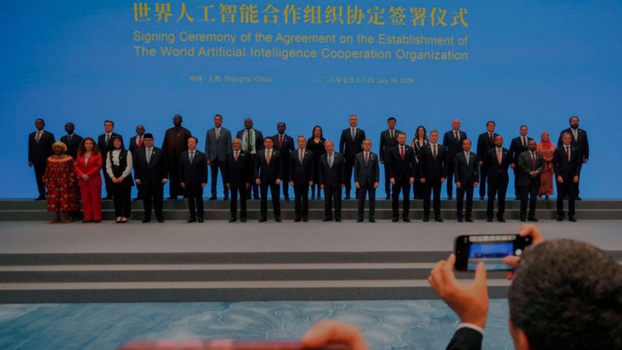 Delegates and government officials standing on stage during the official signing ceremony of the World Artificial Intelligence Cooperation Organization in Shanghai.