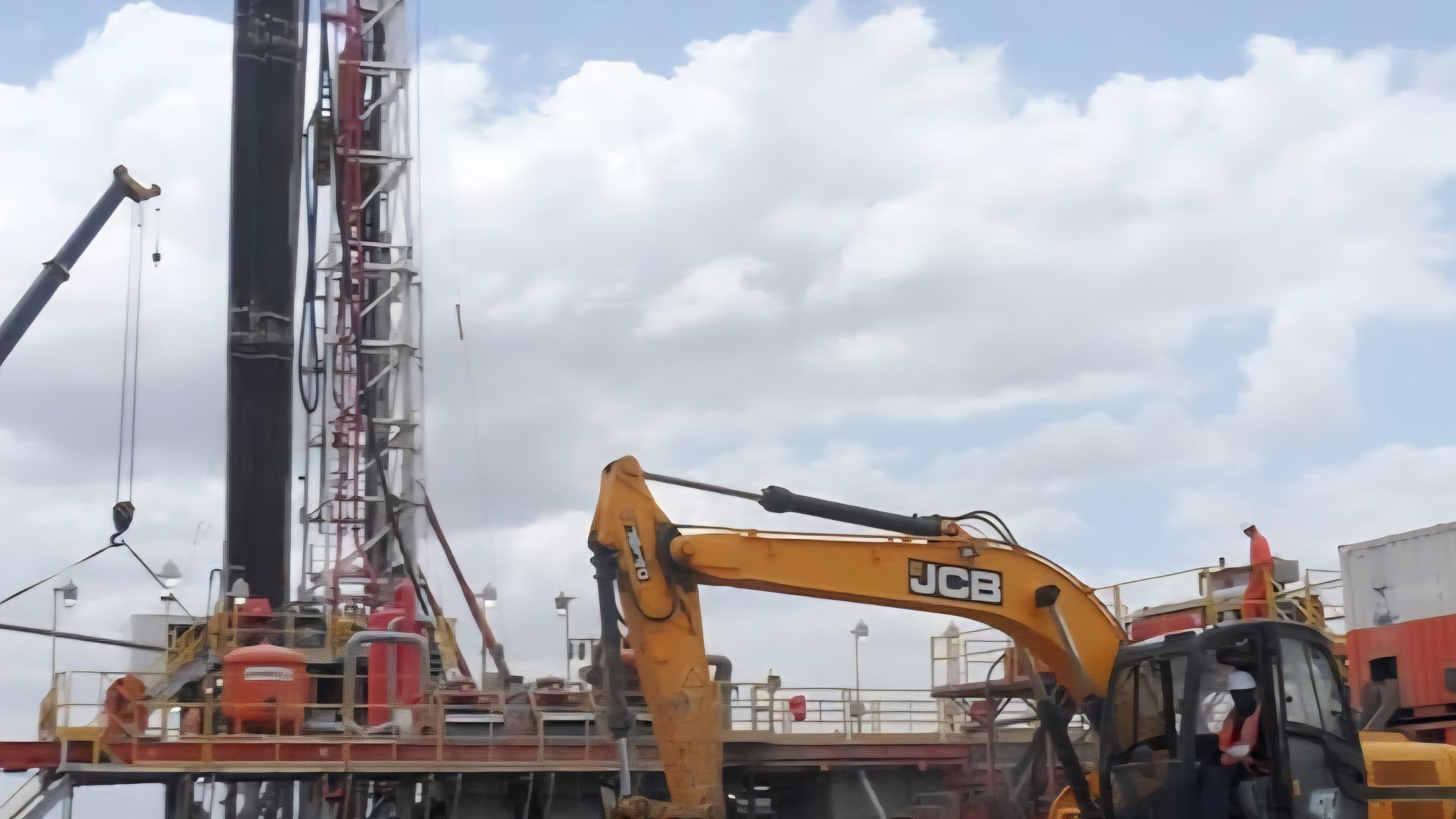 Heavy drilling rig machinery operating at an oil field development site in the arid terrain of Turkana County.