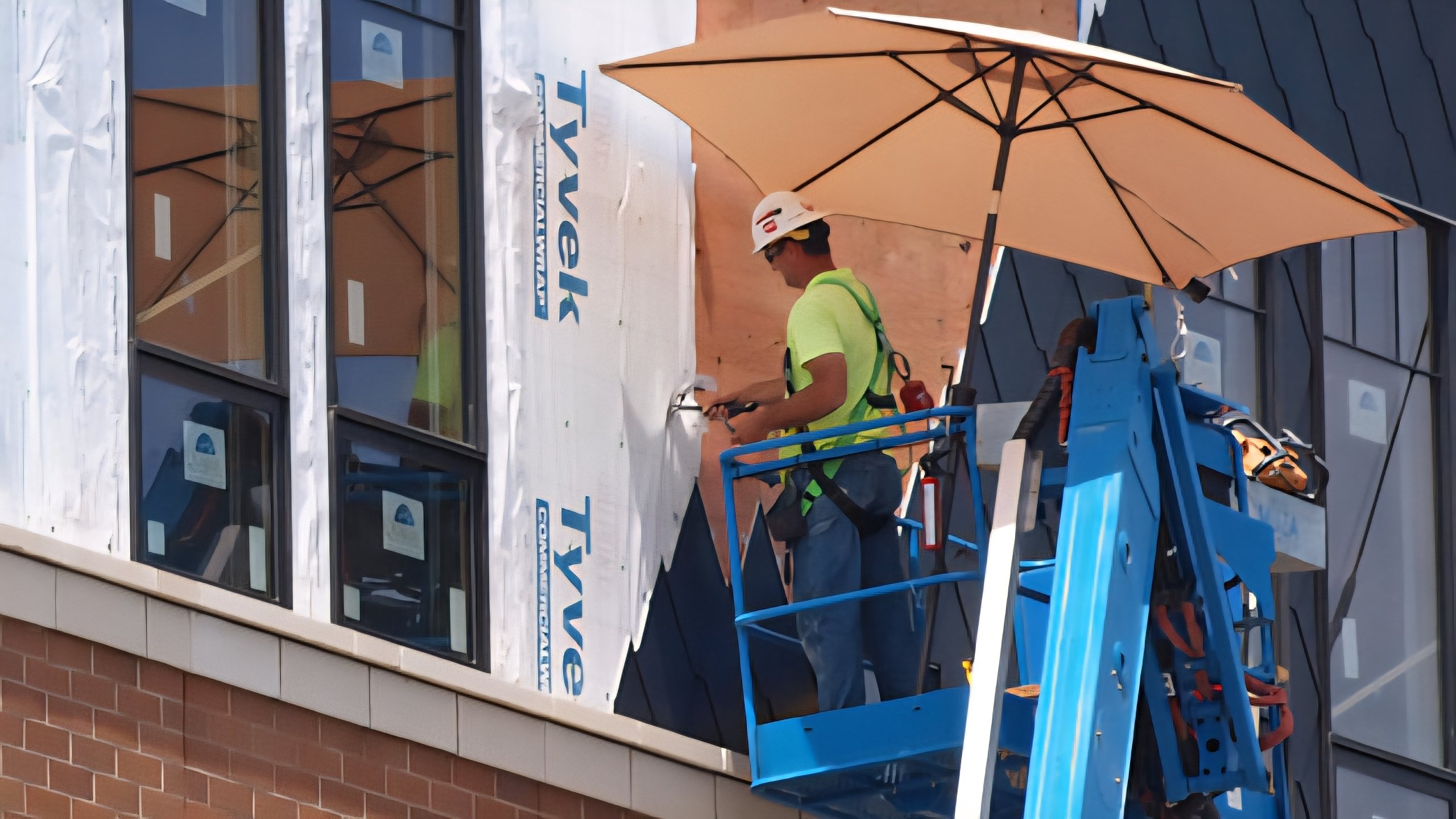 Construction workers taking a break in a shaded area of a building site under a bright sun.